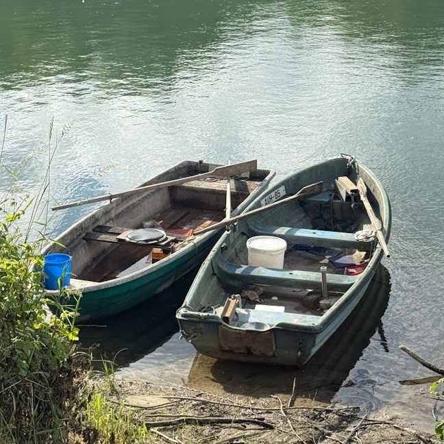 serene riverside scene with two rustic boats